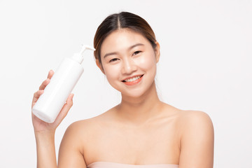 Attractive Asian young woman smile with white teeth holding white Lotion bottle feeling so happy and cheerful with healthy Clean and Fresh skin,isolated on white background,Beauty Cosmetology Concept