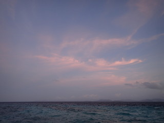 水平線の朝焼けのピンク色の雲