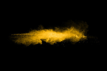 Fototapeta na wymiar Yellow powder explosion on black background. Colored cloud. Colorful dust explode. Paint Holi.