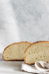 Artisan rustic bread from wheat flour on light grey stone background, selective focus. 