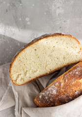 Artisan rustic bread from wheat flour on light grey stone background, selective focus. Top view.