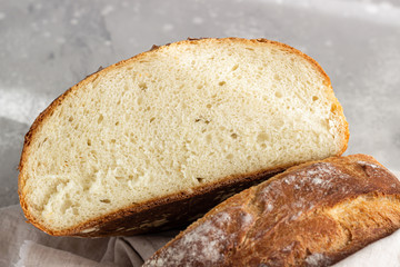 Artisan rustic bread from wheat flour on light grey stone background, selective focus. 