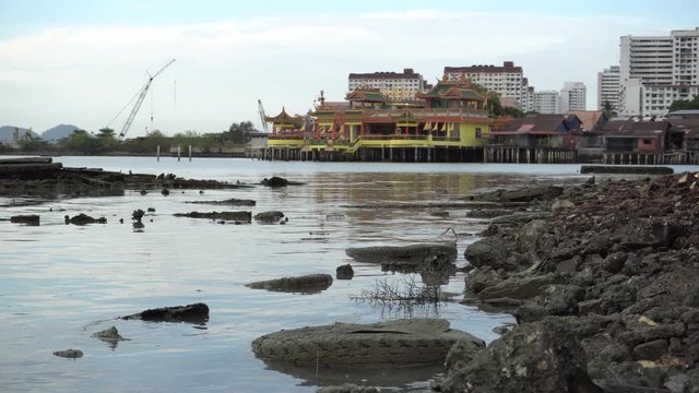Abandoned tire and dirty at coastal near clan jetty. Background is Hean Boo Thean Temple.