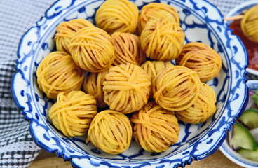Deep Fried Wrapped Pork with Noodle Thai traditional snacks menu ( Thai name is Moo sarong) in Thai style bowl with cucumber salad and sweet chili sauce.