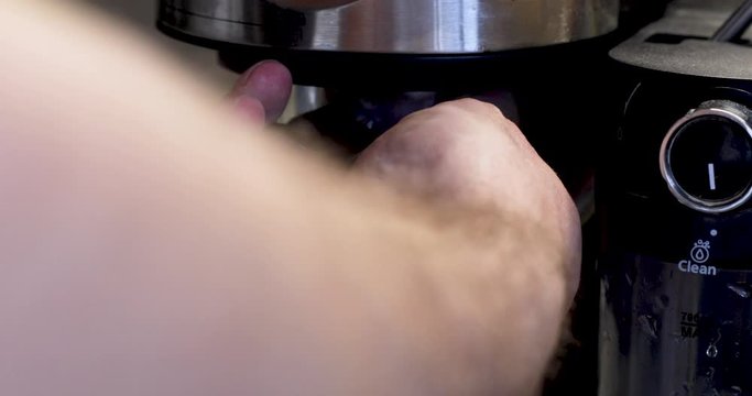 close up of a hand holding a caffee maker 