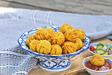 Deep Fried Wrapped Pork with Noodle Thai traditional snacks menu ( Thai name is Moo sarong) in Thai style bowl with cucumber salad and sweet chili sauce.