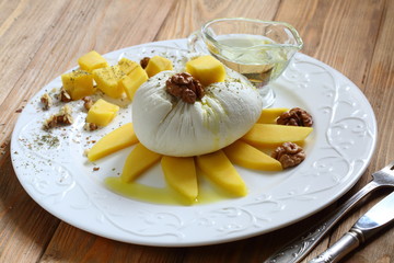 Soft white cheese with mango, walnut and honey