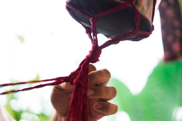 Hand of a craftsman knitting handmade macrame.