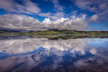 Reflection in the water of Dyrholaos estuary near cape Dyrholaey in Iceland