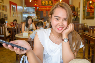 young woman in cafe with mobile phone