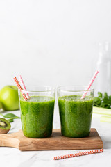 green smoothie of spinach, apple and kiwi on a light background