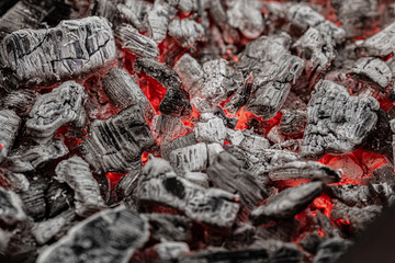 Hot white and black coals smolder in the grill