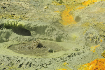 A bubbling volcanic fumarole surrounded by yellow sulfur deposits. White Island, New Zealand