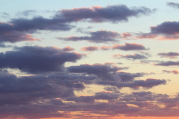 Clouds in the blue sky at sunset or dawn backlit by the sun. Place for text and design.