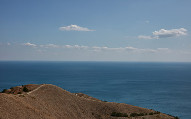 a sea of green hills and blue sky