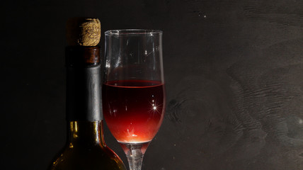 glass of red wine with bottle on golden silver background