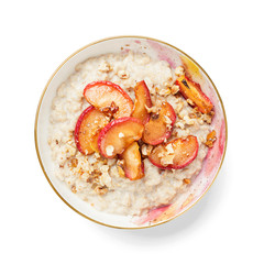 Oat porridge with caramelized apples and nuts isolated on white background