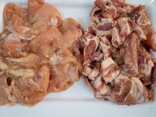 Fresh chicken and sliced pork belly Placed on a large white plate