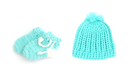 Handmade sweet baby booties and hat isolated on white background