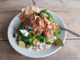 Gado gado dish on wooden table with vegetables egg and satay sauce in perspective
