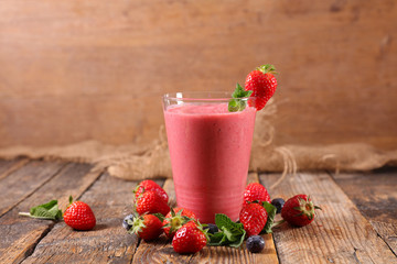 strawberry smoothie- fruit juice on wood background