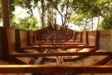 A traditional Cambodian or Khmer boat  called Bon Om Touk being repaired in an island village of...
