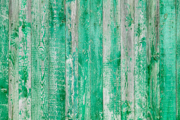 Wooden boards on an old green fence as an abstract background.