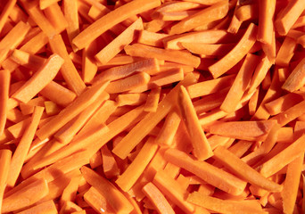 Fresh orange carrots sliced as a background.