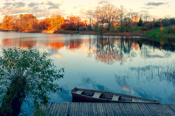 Autumn evening on the lake with a boat at the pier
