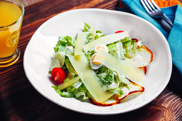 Caesar salad on a white plate top view