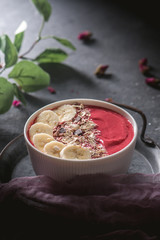 Raspberries smoothie bowl with fresh banana and granola