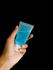Alcohol gel with blue gel helps wash hands, kill the covid virus 2019 in the black background,In pocket size