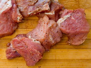 Pieces of pickled raw meat on a wooden board.