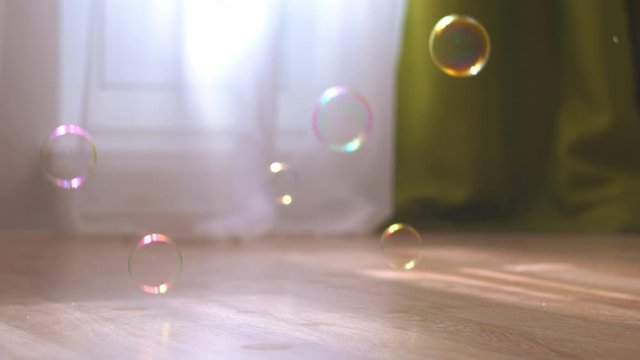background of floating soap bubbles. soap bubbles fall on the floor in the room. a bright room with flying soap bubbles