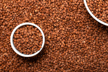Dry buckwheat in white ceramic cup