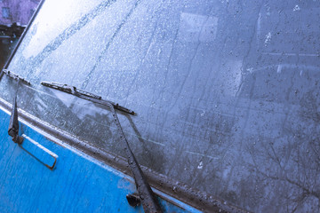 background texture of the blue color of the car surface and .car wipers, where rain and snow drops run down after a storm. the trend color of the year 2020 , the place to promote road safety