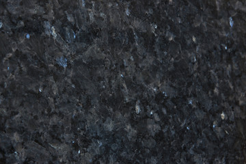 Fototapeta na wymiar Background from gray granite with blue sparkles, this natural stone is called Blue Pearl