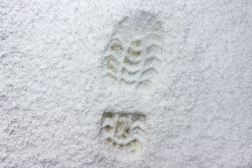 footprints of a man in the fresh snow. Changeable weather due to global warming, in the spring after the rain fell hail