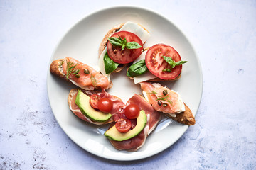 Sandwitches with tamatoes, avocado and salmon on plate
