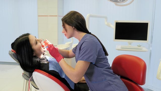 Female dentist doing dental treatment to her patient in clinic