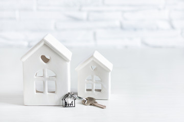 Toy house and key with keychain with family in a house shape. Real estate market concept.