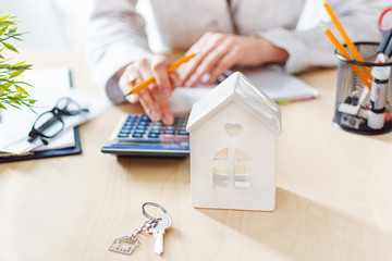 Real estate agent calculating taxes and profits to invest in home buying.