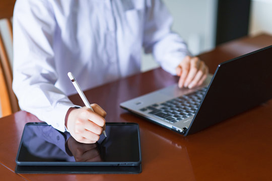 Japanese Remote Worker Using Laptop Computer And Tablet Machine