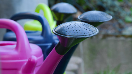 Watering cans wait for their use in the garden season
