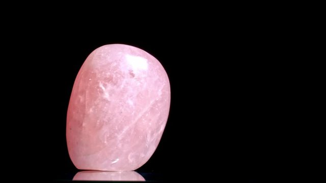 Beautiful uncut rose quartz gemstone,motion black background