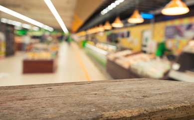 Supermarket background, Counter over blur grocery background, Wooden desk, table, shelf and blur woman shopping at supermarket, Wood counter for grocery store retail product display backdrop, template