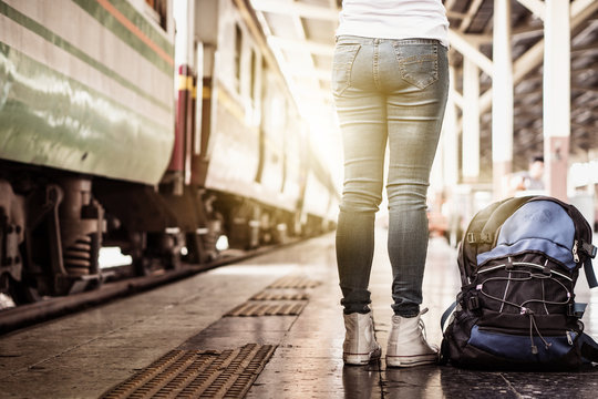 Solo woman backpacker traveler plan safety trip low cost budget summer holiday after coronavirus. Empty tourist on train railway platform. Use bus train sustainable environmental friendly transport