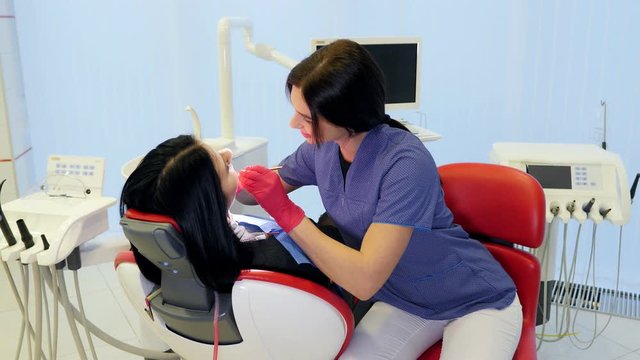 Female dentist doing dental treatment to her patient in clinic