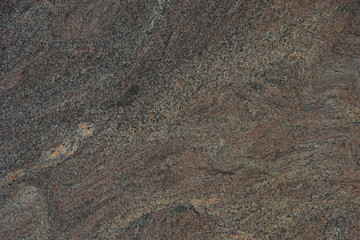 Background from a beautiful natural stone of maroon color with a wavy pattern is called granite Paradiso Classico
