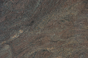 Background from a beautiful natural stone of maroon color with a wavy pattern is called granite Paradiso Classico